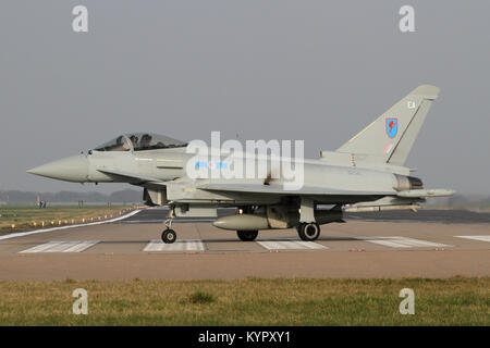 RAF Typhoon rullaggio fuori pista Coningsby dopo lo sbarco come altro emerge dalla nebbia dietro. Foto Stock