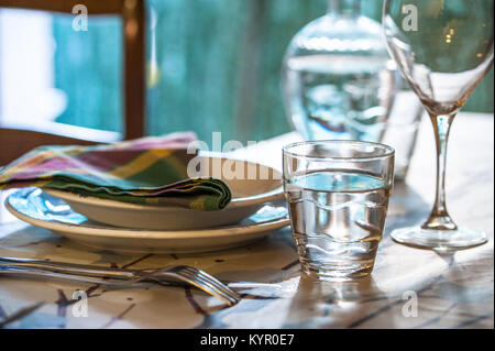Elegante set di tavolo per pranzare in un estate con bianco piatti di porcellana, bianco vintage tovagliolo in pizzo e vetreria Foto Stock