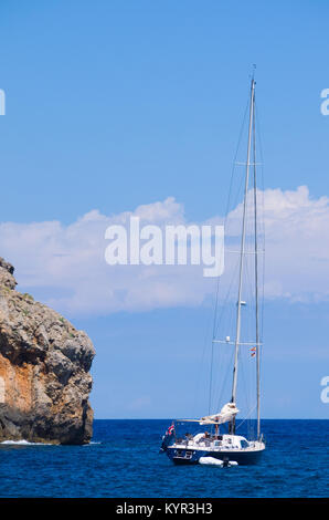 Vista di uno yacht con costa rocciosa a Cala Deia Beach in Mallorca, Spagna. Foto Stock