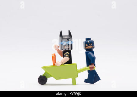 Vacanza di LEGO Batman seduti sulla carriola con Capitan America spingendolo. Foto Stock