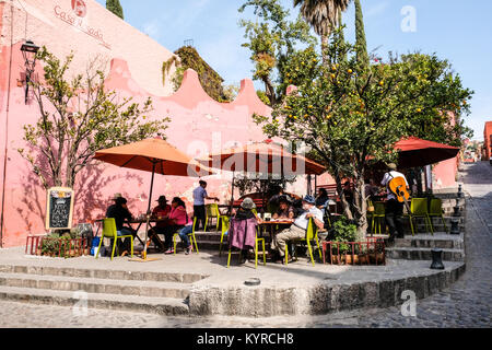 I turisti in un momento di relax a un cafè sul ciglio della strada in corrispondenza di un angolo di strada in San Miguel De Allende,Messico Foto Stock