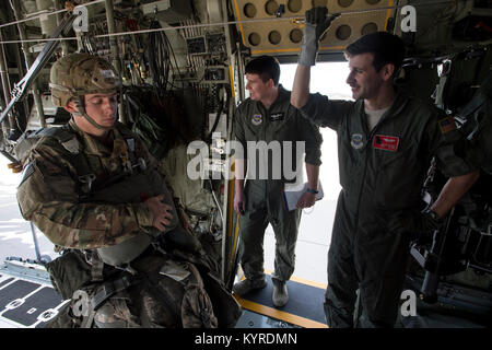 Papa Army Airfield, N.C. - Airman 1. Classe Evan Jobe (centro) e Tech. Sgt. William Wichers (a destra), loadmasters in Georgia Air National Guard's 165Airlift Wing, guarda su come i soldati dell'Esercito 27 del Battaglione ingegnere (Airborne) a bordo di una C-130H Hercules sulla rampa di verde di articolazione durante la formazione di airdrop qui gen. 10, 2018. Avieri in 43d Aria Mobilità Squadron e 43d aria squadrone di base al Papa supportato sia la visita personale di volo e di unità dell'esercito durante il corso di formazione. Il 43d Aria Mobilità Operations Group, che è una parte dell'aria di comando di mobilità, poteri airlift della formazione e del mondo reale, operatio Foto Stock