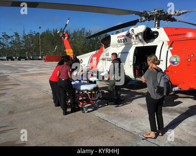 Coast Guard il suo equipaggio a bordo di un MH-60 Jayhawk elicottero dalla stazione aria Clearwater, Florida, medevac un 45-anno-vecchio uomo Venerdì, Gennaio 12, 2018 da Highborne Cay, Bahamas. L'uomo ha subito una lesione alla schiena mentre la vela ed è stato trasportato al personale di pronto soccorso in attesa a Nassau, Bahamas. (U.S. Coast Guard Foto Stock