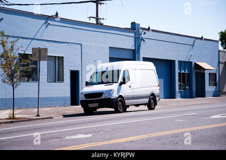 Piccolo e compatto minivan bianco per il trasporto commerciale e small business - comodo e pratico veicolo permanente sulla città urbana street Foto Stock