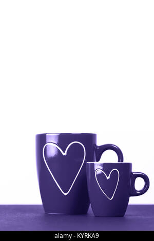 Rosso di due tazze di tè o caffè con cuori. Grandi e piccoli - uomo e donna. Il concetto di amore. Macro. Posto per il testo. Foto Stock