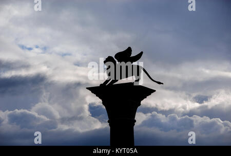 San Marco leone alato antica statua silhouette tra le nuvole Foto Stock