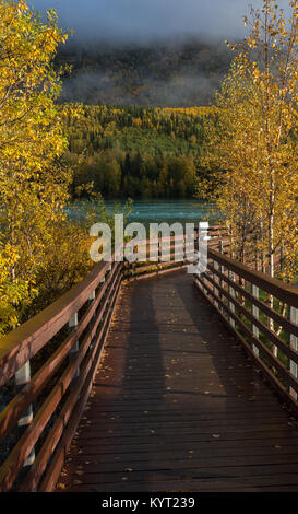 Una passerella in legno conduce giù per il fiume Kenai che è in fase di inondazione in Cooper Landing. Foto Stock