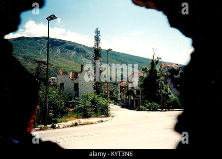 Mostar (Bosnia ed Erzegovina) nel giugno 1995. La città è stata ed è divisa tra musulmani e croati, la linea anteriore diviso la città intera. La foto mostra la vista al di fuori di un foro nella parete del Monastero Francescano al lato musulmana di Mostar. Sullo sfondo le colline che a quel tempo erano sotto il controllo dell'esercito serbo (Repubblica di Srpska). Foto Stock