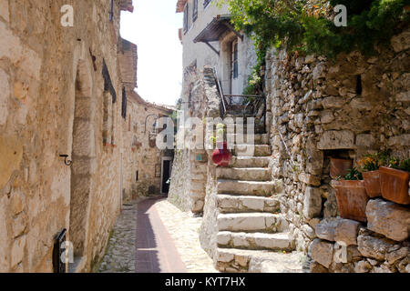 Stretta strada antica e scale nella vecchia città europea di Eze vicino a Nizza Francia Costa Azzurra con rocce bianche e piante Foto Stock