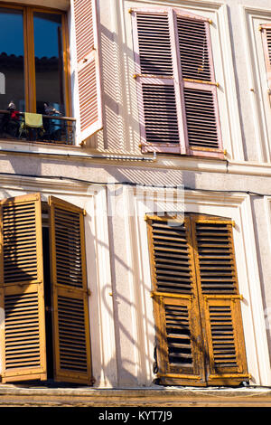 Le finestre della vecchia casa piani con il vecchio stile di persiane in legno con pareti scrostate creare una colorazione della vecchia città provinciale di Nizza in Francia Foto Stock