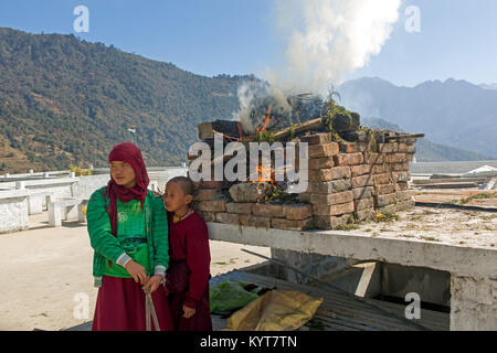 Giovani monaci stanno bruciando ginepro come incenso davanti all'Khinmey Nyingma Monastero di Tawang Foto Stock