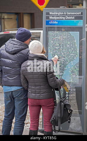 Un turista giovane check out una Citibike mappa stradale su Washington St. nel Meatpacking District di Manhattan, New York City. Foto Stock