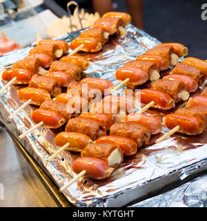 Infilzato su canne di bambù con salsicce e formaggi e bistecca di Amburgo (Coreano street food) Foto Stock