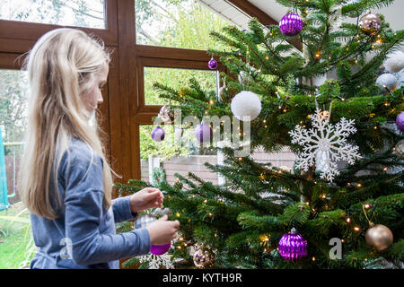 Bambino decorare un albero di Natale vero concetto di natale, kids bambini, speciale tempo, luci baubles celebrazione memoria ricordi d'infanzia, il simbolo del fiocco di neve Foto Stock