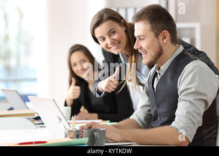 Felice per congratularmi con i colleghi per un lavoratore motivato dopo il raggiungimento di obiettivi in ufficio Foto Stock