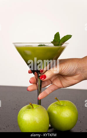 Verde la frutta e la verdura juiced nel bicchiere da cocktail con un rametto di menta Foto Stock