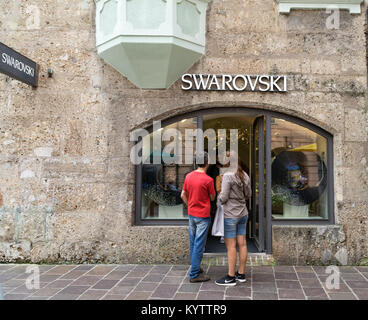 Coppia giovane è in piedi di fronte a shopwindow dei gioielli Swarovski store che si trova in una storica tenement house di Innsbruck, in Austria. Foto Stock