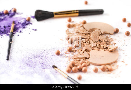 Varie polvere cosmetica con spazzole sul piano portapaziente bianco Foto Stock