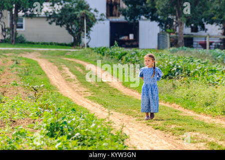 Giovane ragazza in giardino nel Paese Amish in Pennsylvania, STATI UNITI D'AMERICA Foto Stock