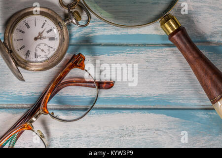 Occhiali,pen,argento orologio da tasca e lente di ingrandimento su legno Foto Stock