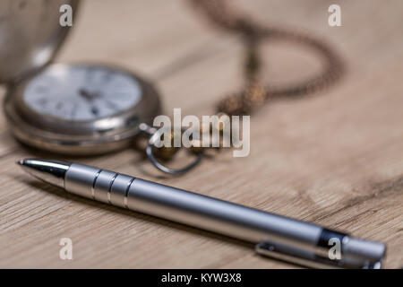 Penna e argento antico Orologio da tasca su legno Foto Stock