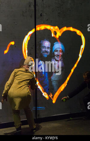 Canary Wharf, Londra, 16 gen 2018. I visitatori hanno divertimento con la luma vernice graffiti di luce l'installazione. Luci d'inverno 2018 a Canary Wharf apre al pubblico. La mostra gratuita include oltre 30 sculture, strutture ed impianti, alcuni interattivi, da luce innovativa degli artisti. Credito: Imageplotter News e sport/Alamy Live News Foto Stock