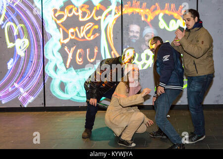 Canary Wharf, Londra, 16 gen 2018. I visitatori hanno divertimento con la luma vernice graffiti di luce l'installazione. Luci d'inverno 2018 a Canary Wharf apre al pubblico. La mostra gratuita include oltre 30 sculture, strutture ed impianti, alcuni interattivi, da luce innovativa degli artisti. Credito: Imageplotter News e sport/Alamy Live News Foto Stock