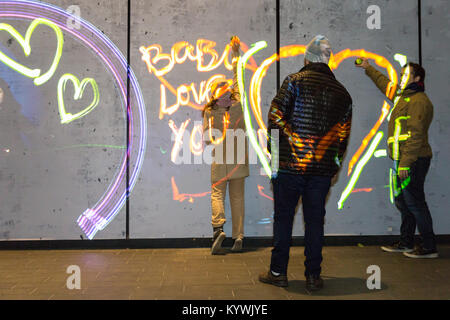 Canary Wharf, Londra, 16 gen 2018. I visitatori hanno divertimento con la luma vernice graffiti di luce l'installazione. Luci d'inverno 2018 a Canary Wharf apre al pubblico. La mostra gratuita include oltre 30 sculture, strutture ed impianti, alcuni interattivi, da luce innovativa degli artisti. Credito: Imageplotter News e sport/Alamy Live News Foto Stock