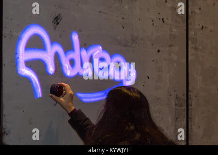 Canary Wharf, Londra, 16 gen 2018. I visitatori hanno divertimento con la luma vernice graffiti di luce l'installazione. Luci d'inverno 2018 a Canary Wharf apre al pubblico. La mostra gratuita include oltre 30 sculture, strutture ed impianti, alcuni interattivi, da luce innovativa degli artisti. Credito: Imageplotter News e sport/Alamy Live News Foto Stock