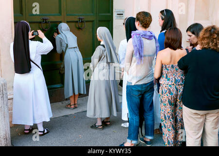 Linea di persone fino ad avere uno sguardo alla Basilica di San Pietro attraverso una piccola toppa, Villa del priorato di Malta, Aventino, Roma, Italia Foto Stock