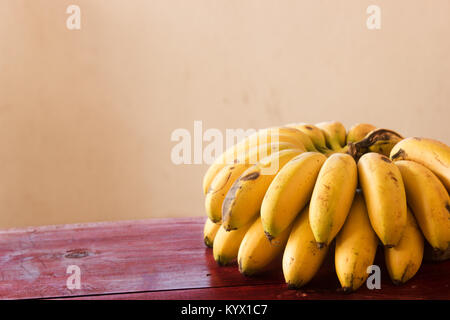 Cluster di mini pisang banane su una tavola di legno Foto Stock