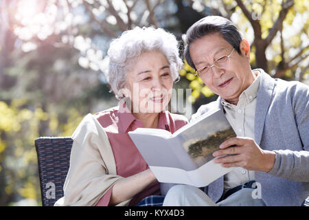 La vecchia coppia leggere sotto il sole Foto Stock