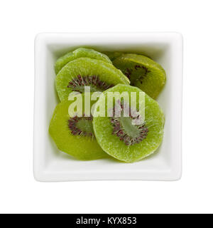 Pezzi di canditi di kiwi in un recipiente quadrato isolato su sfondo bianco Foto Stock