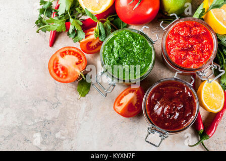 Indian cibo tradizionale, Set di tre chutney per Chaat e Sev Puri - dolce data-tamarindo, il coriandolo-verde menta e il peperoncino rosso aglio, sulla pietra beige Foto Stock