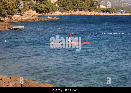 Dalmazia, Croazia - 28 giugno 2011: l'uomo gode di kayak da mare a Brela, Dalmazia, Croazia. Nel 2011 11,2 milioni di turisti hanno visitato la Croazia, la maggior parte di loro in Foto Stock