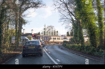 Vetture attendere a nord del convoglio ferroviario passa Hall Dene passaggio a livello vicino a Seaham, County Durham, England, Regno Unito Foto Stock