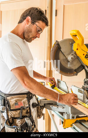 Una metà 30's uomo caucasico lavorando la misurazione di un pezzo di rivestimento prima che egli lo taglia modello di rilascio: 20060823 mr A Foto Stock