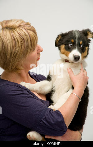 Signora proprietario del cane di coccole felicemente il suo nuovo cucciolo Foto Stock