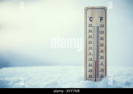 Termometro sulla neve mostra basse temperature sotto zero. Basse temperature in gradi Celsius e Fahrenheit. Freddo inverno dieci sotto zero. Foto Stock