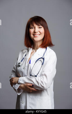 Foto di sorridere medico donna in bianco camice e con phonendoscope Foto Stock