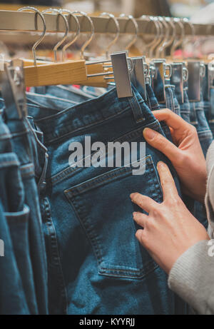 Donna scelta di jeans nel negozio di abbigliamento. Foto Stock