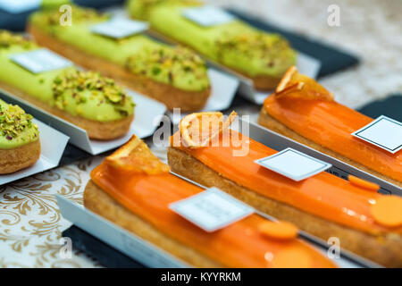 Gustose torte eclair vetrate con orange chiudi Foto Stock