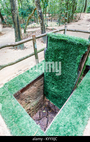 Deadly pit con nascosto booby porta intrappolato nell'iconico di Cu Chi rete di tunnel, nascosto Viet Cong gallerie (Saigon Ho Chi Minh City), il sud del Vietnam Foto Stock