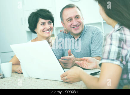Coppia positiva ascolto di donna con notebook in ambienti interni Foto Stock