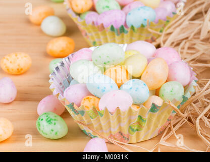 Pasqua colorati Jelly Beans in bicchieri di carta su un sfondo di legno Foto Stock