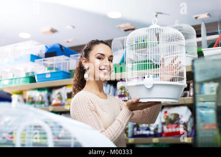 Femmina felice di acquisto dei clienti per gabbia quinea in negozio Foto Stock