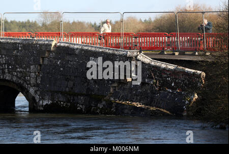 Persone di visualizzare il danno per la lana di vecchio ponte sul fiume Frome in lana, Dorset. La Elizabethan ponte che presenti nel Thomas Hardy romanzo Tess dei D'Urbervilles, parzialmente crollata a seguito dei recenti intemperie. Foto Stock