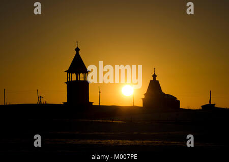 Chiesa di legno e il campanile al tramonto. Russia, Arkhangelsk regione Foto Stock