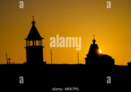 Chiesa di legno e il campanile al tramonto. Russia, Arkhangelsk regione Foto Stock