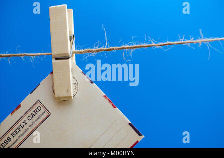 Busta del messaggio su una fune su uno sfondo blu Foto Stock